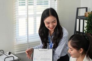 Businesswoman showcasing a report chart while discussing strategies with a colleague in a bright office photo