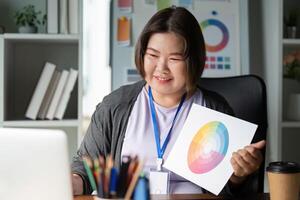Enthusiastic graphic designer showcasing a color wheel and discussing designs in a modern creative workspace photo