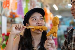 Friends engaging in playful banter over street food, sharing crispy snacks while traveling in a vibrant market photo
