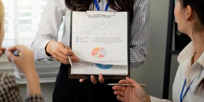 Multi-ethnic team reviewing report chart during a strategic business meeting in a modern office setting photo