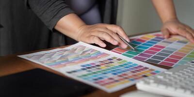 Focused graphic designer selecting color swatches and working on design concepts in a modern office space photo