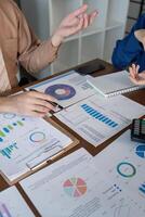Accountants discussing financial trends and metrics analysis using charts in a professional office photo