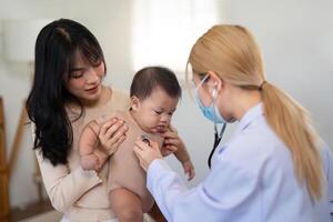 Doctor using stethoscope on baby during a parental health consultation photo