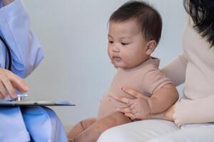 Baby's health checkup with doctor and parent support photo