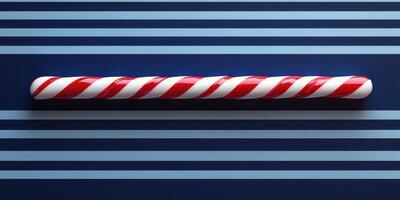 Red and white striped candy stick resting on blue striped background brings holiday cheer photo