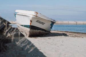 An old fishing boat rests by the port, showing signs of wear and time, adding to the charm of the harbor photo