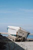 A vintage fishing boat is moored in the port, its worn wooden frame telling stories of past journeys. photo