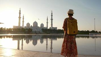 female tourist enjoys serene moment while admiring stunning view of the Sheikh Zayed Mosque in Abu Dhabi. grand architecture and peaceful surroundings, view from park Wahat AlKarama video