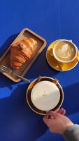 coffee two stand on a blue table in a coffee shop restaurant and Croissant with chocolate breakfast date cappuccino latte video