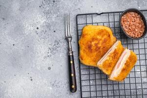 Fried Chicken cordon bleu cutlet with cheese and ham in breadcrumbs. grey background. top view photo