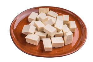 Uncooked Diced soybean tofu cheese on plate isolated on white background. top view photo