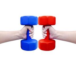 A person's hand holds a red and blue dumbbell. photo