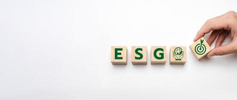 Wooden Blocks Representing ESG Principles - Environmental, Social, and Governance Icons with a Hand Adding a Goal Symbol, Emphasizing Corporate Responsibility, Sustainability, and Ethical Practices photo