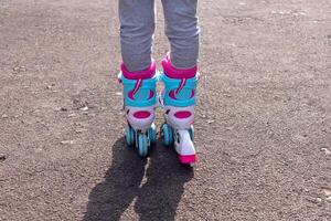 Rear view of a little girl's feet wearing roller skates photo