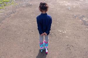 Rear view of a little girl playing roller skates photo