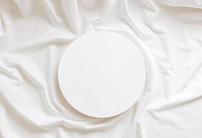 Top view of round podium display for cosmetics product presentation on smooth elegant white cloth fabric background photo