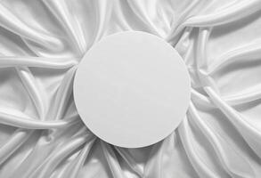 Top view of round podium stand for cosmetics product presentation on smooth elegant white cloth fabric background photo