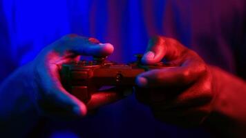 African American man focuses intently on gaming, gripping a controller with skillful hands. The neon backdrop creates a futuristic vibe, enhancing the excitement. video