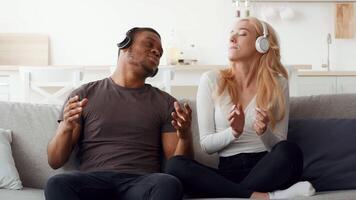 A millennial married couple shares a moment of joy while listening to music at home. Their bond is evident as they engage in an affectionate and fun experience together. video