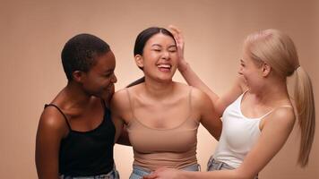 Three friends are laughing and having fun, posing playfully against a soft, light background. Their expressions show joy and camaraderie during a relaxed gathering. video