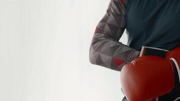 A young man engages in a workout routine at home, showcasing his fitness journey. He wears sport attire and boxing gloves while preparing for his training session, emphasizing strength and dedication. video