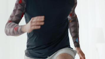 A young man engages in a workout at home, showcasing his commitment to fitness. He is jogging in a comfortable outfit, emphasizing indoor exercise routines for active individuals. video