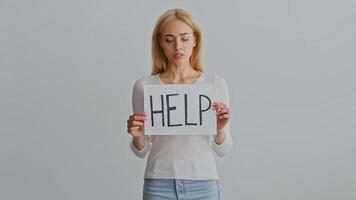 A young woman stands alone in a minimalist environment, appearing contemplative and introspective. Her thoughtful expression hints at personal struggles related to domestic challenges. video