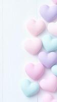 Pastel colored hearts arranged on light background create soft, romantic feel photo