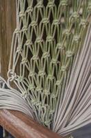Close-up of a weathered rope hammock, showcasing intricate knotwork and texture. High quality photo