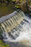 small waterfall cascading over wooden posts, creating a tranquil scene. High quality photo