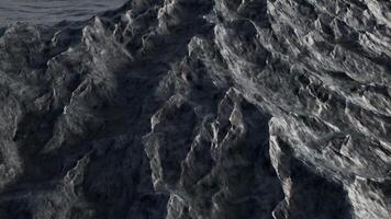 Abstract rugged wave surface with rock-like texture, featuring dark grey tones and jagged edges for a raw, natural effect video