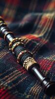 Scottish bagpipe with intricate gold rings on tartan fabric. Burns Night, Tartan Day vertical banner photo