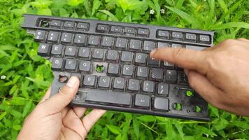 encontrado uma quebrado computador teclado dentro a verde Relva área video