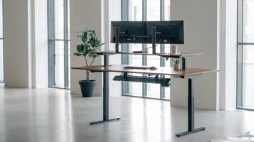 Height-adjustable standing desk in contemporary office space filled with natural light, promoting wellness and ergonomic work habits. Productivity concept photo