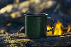Warm cup of coffee resting on a log by a campfire during a peaceful evening in nature photo