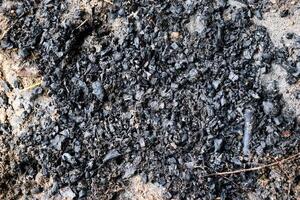 The surface of burnt wood as the remains of a campfire. photo