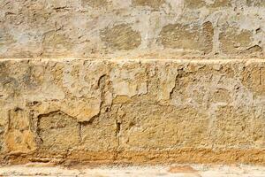The weathered face of a stone wall in the historic streets of Malta. photo