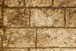 The rustic surface of a stone wall lining Malta's historic passageways. photo
