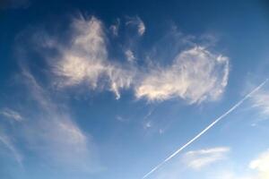 A patchy canvas of bright clouds paints the serene summer sky. photo