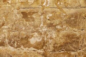 The surface of an old stone wall in the alleyways of Malta's historic towns. photo