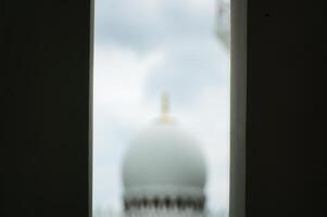 Abstract View of a Distant Sheikh Zayed Grand Mosque Dome Framed by Rectangular Structure photo