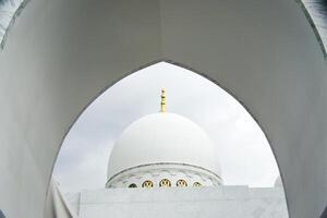 Architectural View of a Sheikh Zayed Grand Mosque Dome Through an Arched Window photo