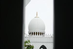 Sheikh Zayed Grand Mosque Dome Against Cloudy Sky Viewed Through Structure photo