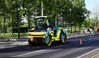 Large view on the road rollers working on the new road construction site on a shunny day photo