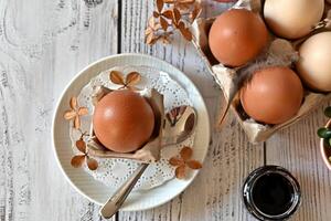 The bowl of eggs is the central focus of the image, while the flowers serve as a frame and add a sense of balance and harmony. photo