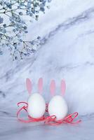 A white card, blank and ready for a message, sits among soft white flowers and speckled quail eggs photo