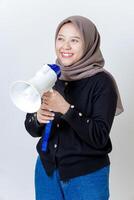 A smiling woman wearing a hijab holds a megaphone isolated on white photo