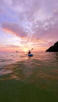 Woman Kayaking On Calm Sea Towards Sunset With Beautiful Colors In The Sky video