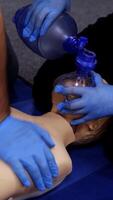 Chest compression on a dummy. Cardiopulmonary resuscitation. Training session on a chest compression and breathing by practitioners. Close-up. Vertical video