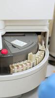 Apparatus in the blood test laboratory moving the set of test tubes. Equipment in the science lap. Top view. Vertical video